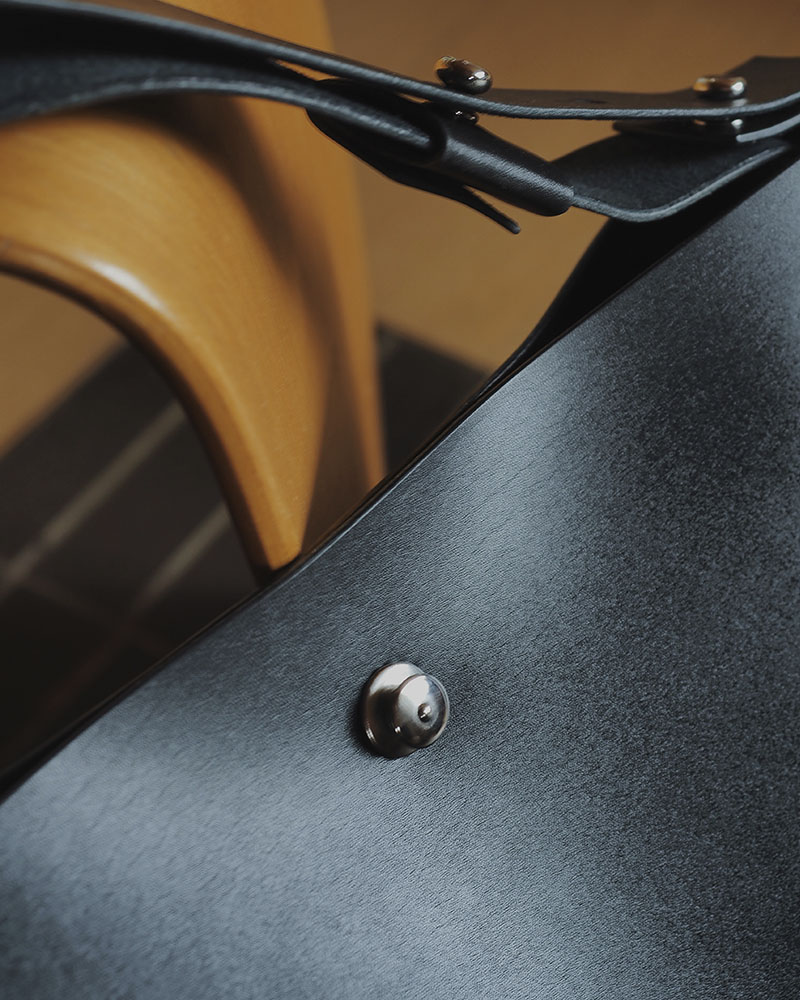 En minimalistisk og funktionel skuldertaske i sort kernelæder, designet til både hverdag og arbejde. Tasken rummer ét stort hovedrum med god plads til de ting, du har brug for – uanset om det er computer, dokumenter eller personlige ejendele. De brede stropper, monteret med solide nitter, gør den behagelig at bære over skulderen, og læderet vil med tiden udvikle en smuk patina, som gør hver taske unik. En enkel og tidløs taske, der kombinerer æstetik med holdbarhed – skabt til at følge dig i mange år fremover.