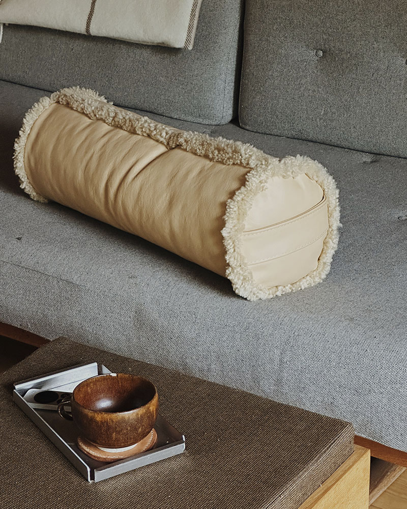 Cylinder pude i blødt læder med rulam kanter – dekorativ og funktionel